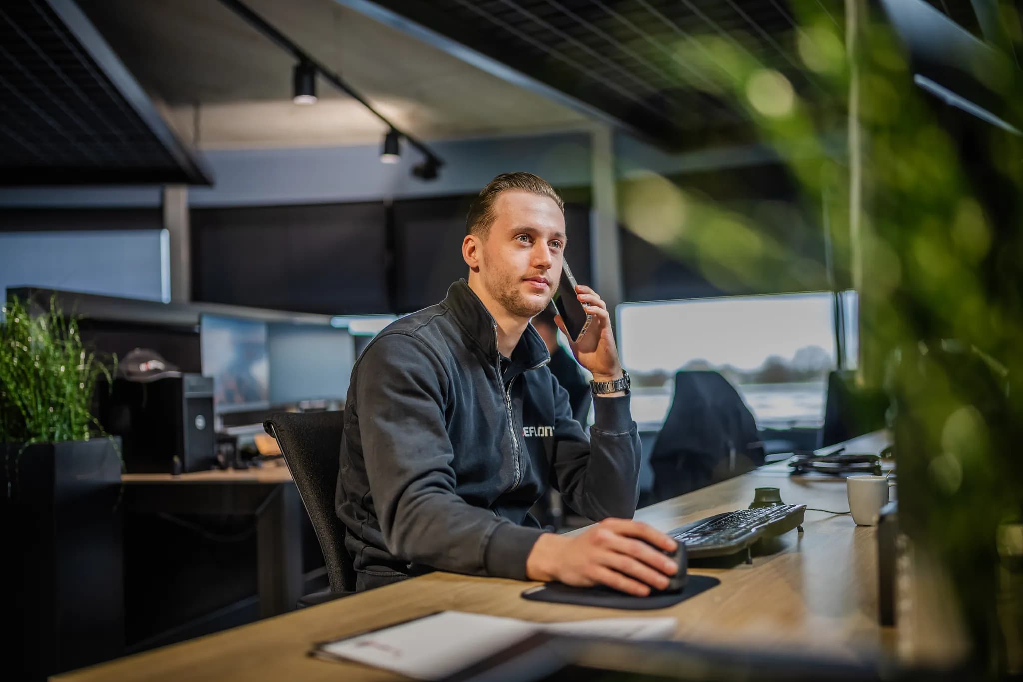 Hoeflon medewerker met een telefoon aan zijn oor