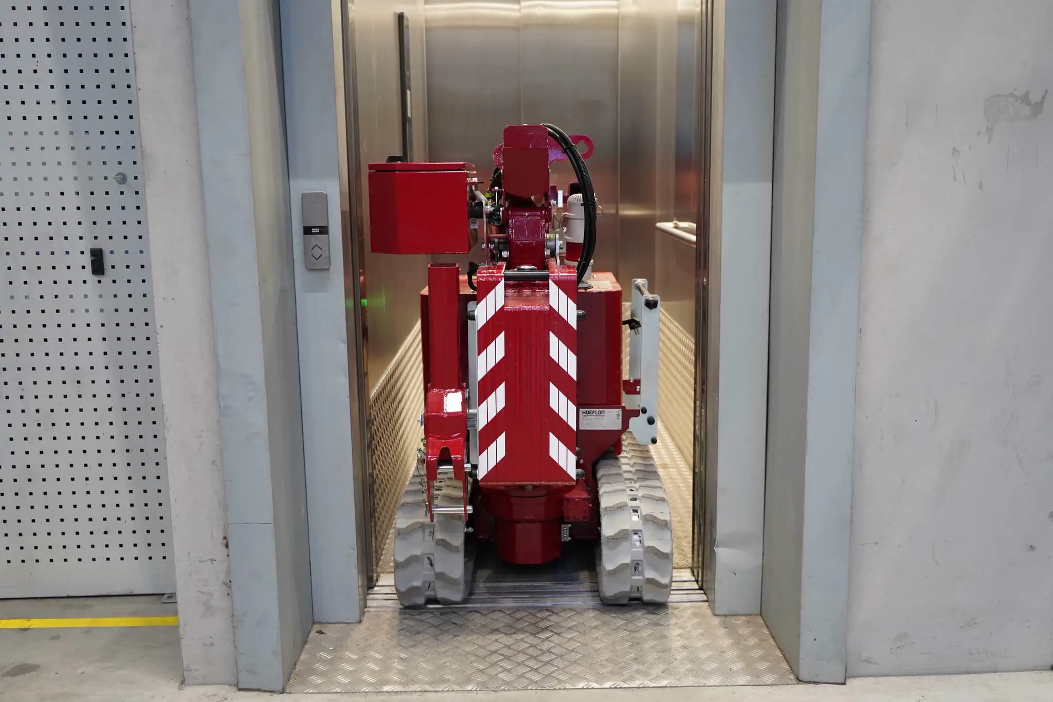 Image of the Hoeflon C1e crane in transport mode inside an elevator.